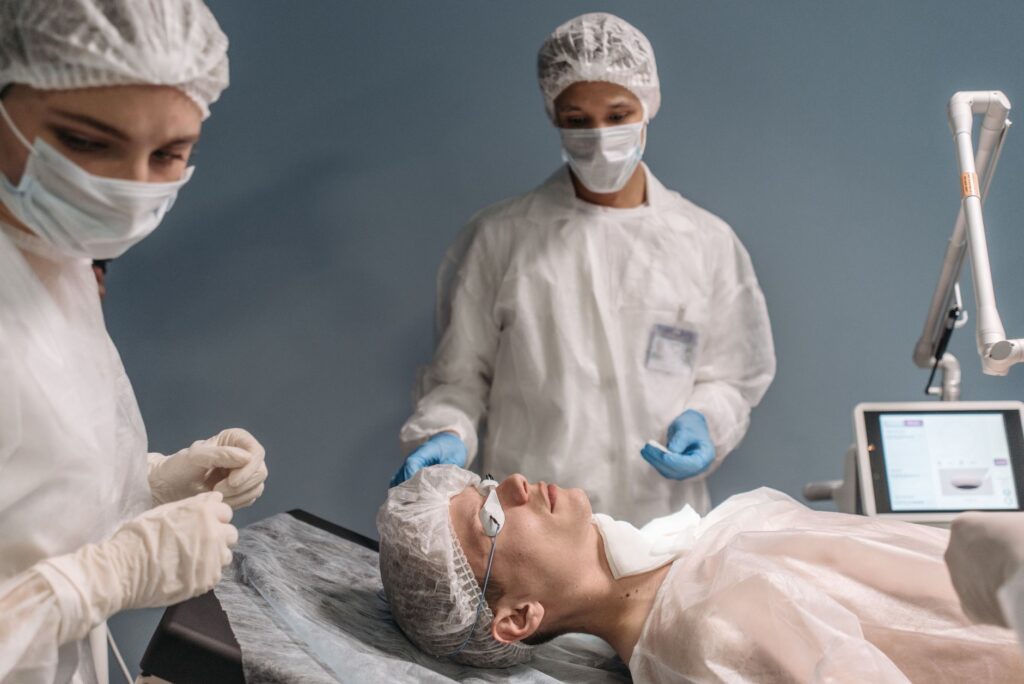Medical team in protective gear prepares for surgery, focusing on patient care and safety.